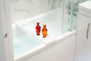 two bottles sitting on a shelf in a bathroom at Luxury Living Away From Home in Earlswood +36 photos