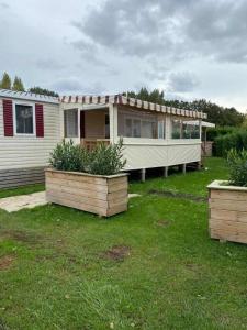 una casa con dos plantadores en un patio en davorel mobil home, en Les Mathes