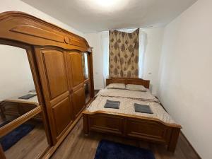- une petite chambre avec un lit et une armoire en bois dans l'établissement Ideal Home Copou, à Iaşi