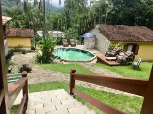 een achtertuin met een zwembad en een huis bij Chácara kiwi in Paraty