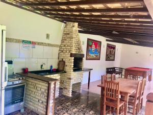 een keuken en eetkamer met een stenen open haard bij Chácara kiwi in Paraty