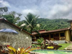 een huis met een zwembad en een resort bij Chácara kiwi in Paraty