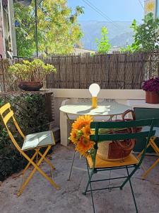 索列爾的住宿－Casa Es Mercat，桌子、两把椅子和一张桌子,上面有向日葵