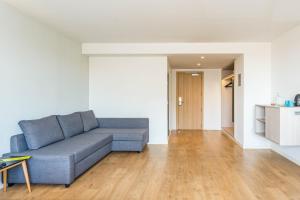 sala de estar con sofá azul y suelo de madera en ARTIEM Madrid, en Madrid