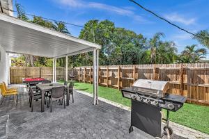 a backyard with a grill and a table and chairs at 3 Bedroom Villa In F Lauderdale Casino & Beach in Fort Lauderdale