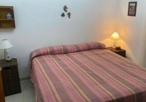a bedroom with a bed with a striped bedspread at Casa POTRERO DE LOS FUNES 2025-2026 in Potrero de los Funes