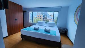 Un dormitorio con una cama grande con una ventana grande. en Hotel Blue Zafiro, en Bogotá 31 fotos más