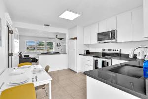 a kitchen with white cabinets and a table and chairs at 3 Bedroom Villa In F Lauderdale Casino & Beach in Fort Lauderdale