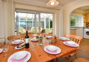 a wooden table with glasses and a bottle of wine at Mor Gragen in Abersoch