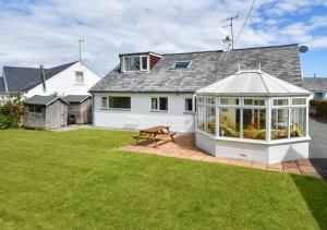 a white house with a conservatory in a yard at Mor Gragen in Abersoch