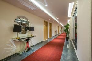 a long hallway with a red carpet and a mirror at Hotel Midori Vithalapur in Vithalpur