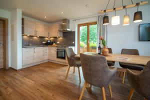 a kitchen with a wooden dining table and chairs at Panoramablick Heimen in Hopferau
