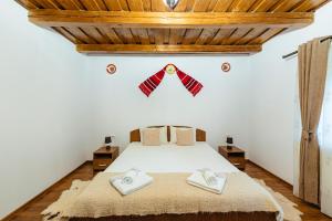 - une chambre avec un lit et 2 serviettes dans l'établissement Pensiunea Ioana, à Poeni