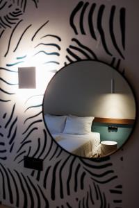 un riflesso a specchio di un letto in una stanza di K2 Suites Kalamata a Kalamáta