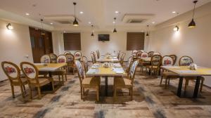 a dining room with wooden tables and chairs at Hotel Midori Vithalapur in Vithalpur