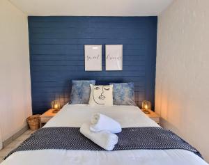 a bedroom with a bed with a blue wall at La Ballito 305 in Ballito