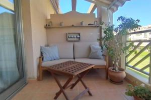 - un balcon avec un canapé et une table dans l'établissement Apartamento El Faro, Sotavento, playa la tejíta, à La Tejita