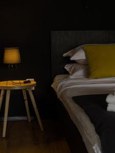 Un dormitorio con una cama y una lámpara en una mesa lateral. en Nordic Villa en Brasov
