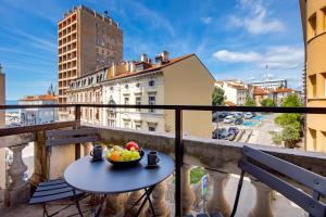 a bowl of fruit on a table on a balcony at Apartments & rooms ONE WORLD in Rijeka