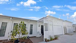a white house with a garage at Family-friendly Seaside Gem in Urangan