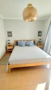 1 dormitorio con cama y lámpara de araña en Apartamento El Faro, Sotavento, playa la tejíta en La Tejita