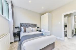 a bedroom with two beds and a window at Avari Apartments - Hatton Collection in London
