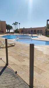 una piscina con un banco frente a ella en Apartamento El Faro, Sotavento, playa la tejíta en La Tejita