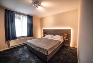 een slaapkamer met een bed en een groot raam bij Hotel Du Commerce in Oostburg