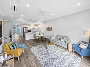 a living room with a couch and chairs and a table at Family-friendly Seaside Gem in Urangan
