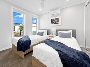 1 dormitorio con 2 camas y ventana en Family-friendly Seaside Gem en Urangan