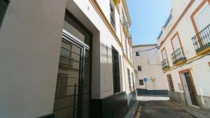 Une allée avec une porte ouverte dans un bâtiment dans l'établissement RentalSevilla Cardenal Cervantes, à Séville