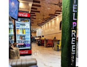 a coca cola refrigerator in a restaurant with people eating at Hotel Preeti,Lalitpur in Lalitpur