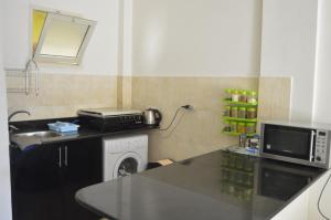 a kitchen with a counter top and a microwave at f- ground floor with garden in Hurghada