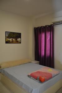 a bed in a bedroom with a purple curtain at f- ground floor with garden in Hurghada