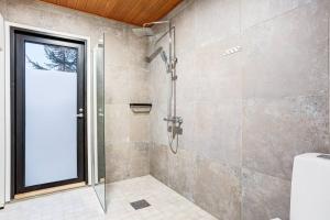 a shower with a glass door in a bathroom at Villa Karina - Beachfront with Jacuzzi in Porvoo +28 photos