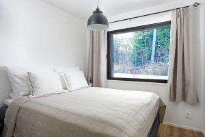 a bedroom with a bed and a large window at Villa Karina - Beachfront with Jacuzzi in Porvoo