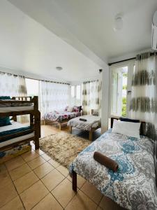 a bedroom with two beds and a living room at Casa Cinza in Ponta do Ouro