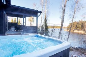 a jacuzzi tub with a view of a lake at Villa Karina - Beachfront with Jacuzzi in Porvoo