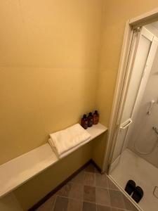 a bathroom with a tub and a shower with a towel at PAThouse台东区店 in Tokyo