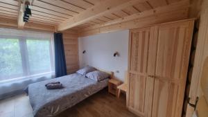 a small bedroom with a bed and a large window at Pod Gruszą in Dzianisz