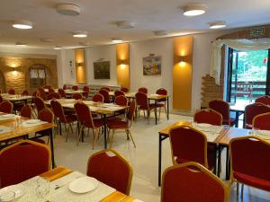 a dining room with tables and red chairs at Centrum Wypoczynku ODYS in Tresna
