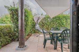 un tavolo e sedie con ombrellone su un patio di [Ca' Roby] Malpensa Airport relax - Free Wifi a Vizzola Ticino