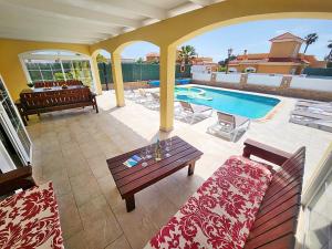 a patio with a table and a swimming pool at Villa Amarillo in Caleta De Fuste