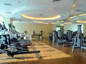 a gym with treadmills and ellipticals in a room at Tranquil Studio Marina View in Dubai