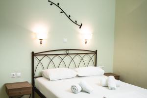a bedroom with a bed with white sheets and pillows at Konstantinos Hotel & Apartments 2 in Nydri