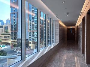 a hallway in a building with large windows at Tranquil Studio Marina View in Dubai