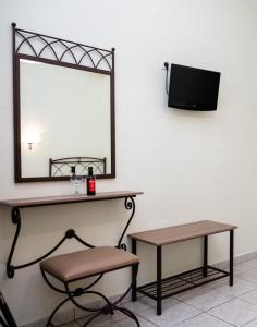 a mirror and a chair and a table and a stool at Konstantinos Hotel & Apartments 2 in Nydri