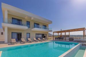 a villa with a swimming pool and a house at Mont Fleury Resort in Koskinou