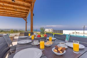 a table with plates of food on top of a balcony at Mont Fleury Resort in Koskinou