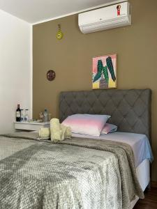 a bedroom with a bed with a gray headboard at Casa do Zafer in Sao Paulo